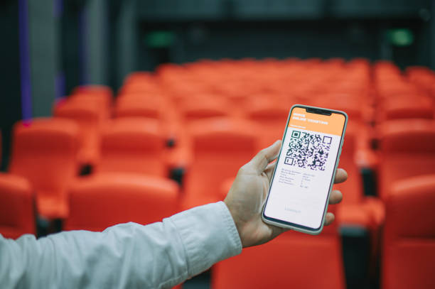 asian chinese man using mobile app cinema movie e-ticketing reservation looking for seat inside cinema hall - concert stock pictures, royalty-free photos & images