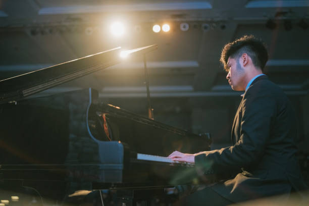 asian chinese teenage boy pianist performing solo on stage - concert stock pictures, royalty-free photos & images