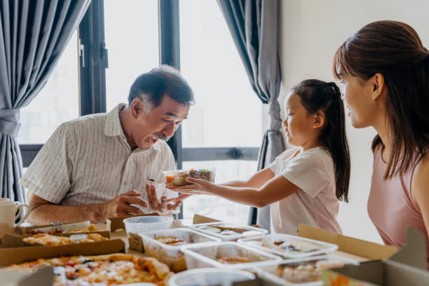 asian family eating take away food at home - junk food stock pictures, royalty-free photos & images