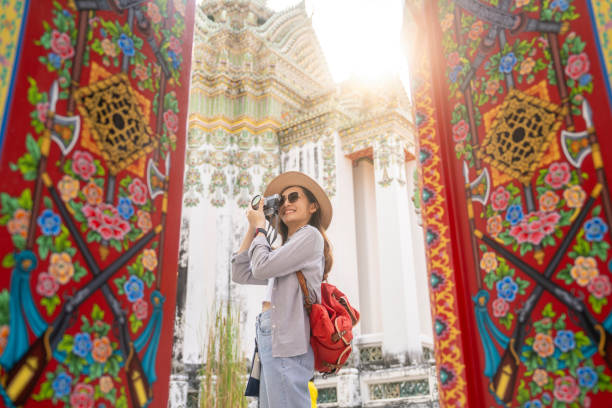 asian female traveler enjoying view of famous wat pho in bangkok - travel stockfoto's en -beelden