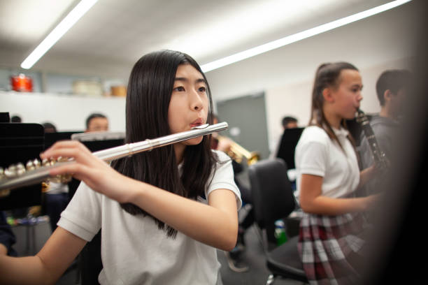 asian korean girl junior high school student teenager playing flute in music band practice - concert stock pictures, royalty-free photos & images