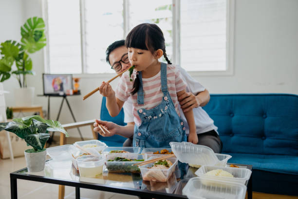 asian man having take out food with his daughter - junk food stock pictures, royalty-free photos & images