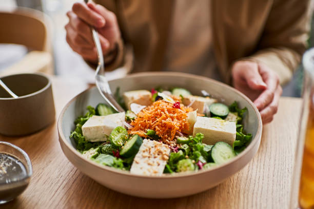 asian woman enjoying lunch at a vegan cafe. - food stock pictures, royalty-free photos & images
