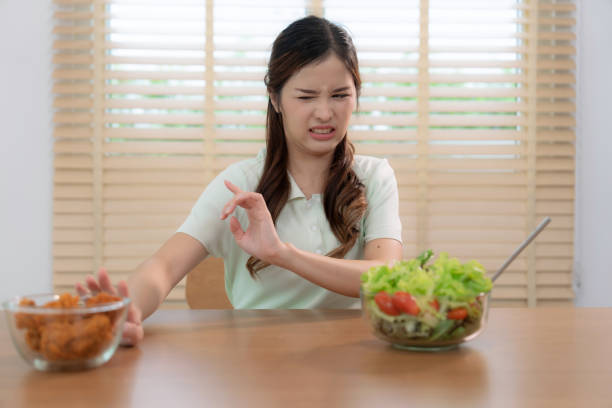 asian woman refusing to eat fried chicken for good health. - junk food stock pictures, royalty-free photos & images