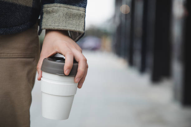 asian woman walking with coffee in a reusable cup - junk food stock pictures, royalty-free photos & images