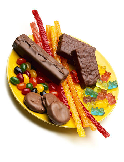assorted candy on plate - junk food stock-fotos und bilder