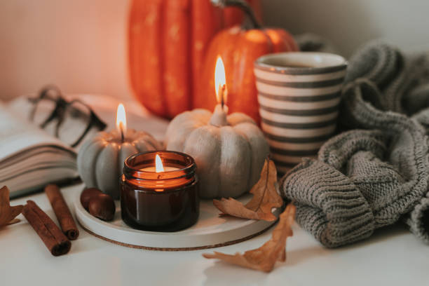 atmospheric candles shape of pumpkin, gray sweater, autumn decor on table. cozy autumn lifestyle, hygge concept. still life. - home decoration stock pictures, royalty-free photos & images