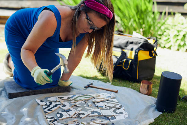 attractive woman doing diy mosaic in garden - garden decoration photos et images de collection
