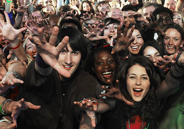 audience at concert reaching hands forward, smiling - concert stock pictures, royalty-free photos & images