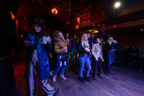 audience at live show dancing, chatting and looking at phones - concert stock pictures, royalty-free photos & images