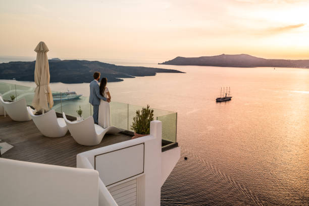 authentic wealth - rich couple standing on terrace with amazing sea view - travel stock pictures, royalty-free photos & images