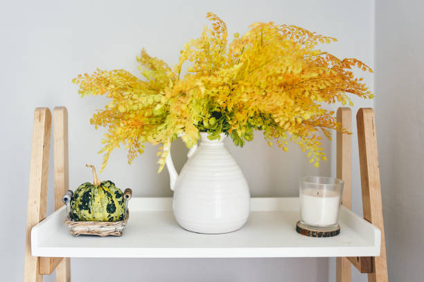 autumn home decor with decorative small pumpkins, flowers in a white vase and candles - home decoration stock pictures, royalty-free photos & images