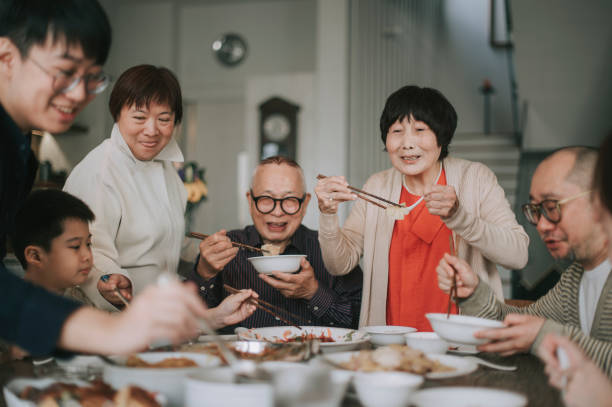 aziatische chinese familie chinees nieuwjaarsreüniediner dat traditionele schotels bij eettafel heeft - food stockfoto's en -beelden