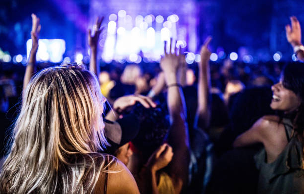 back view of carefree woman dancing on music concert by night. - concert stock pictures, royalty-free photos & images