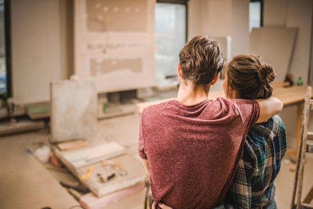 back view of embraced couple in their renovating apartment. - home decoration stock pictures, royalty-free photos & images