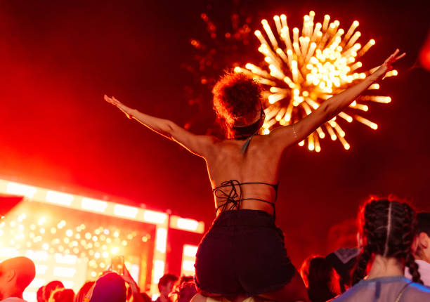 backshot of girl at festival watching fireworks - concert stock pictures, royalty-free photos & images