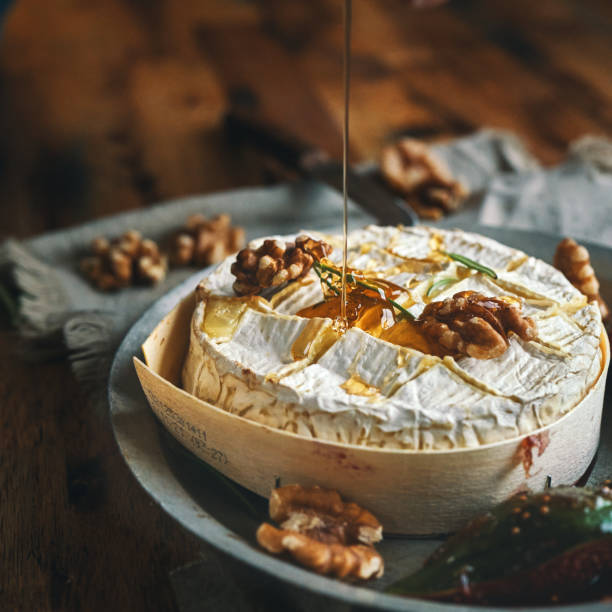 baked camembert cheese served with honey and fresh figs - food stock pictures, royalty-free photos & images