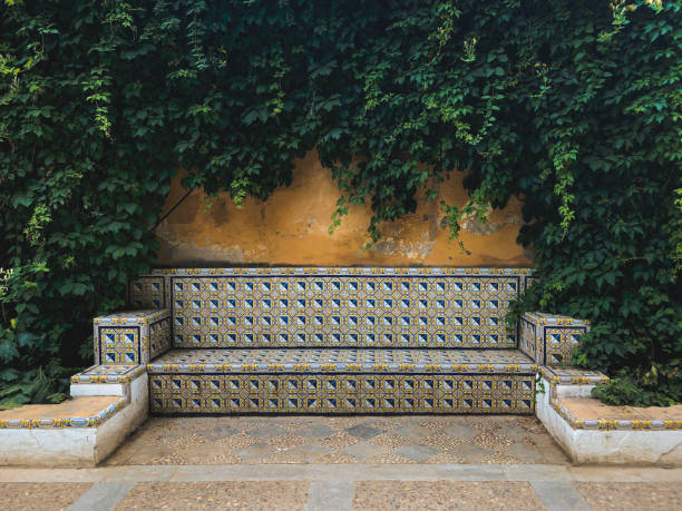 bank decorated with tiles in a garden of sevilla oldtown - garden decoration stockfoto's en -beelden