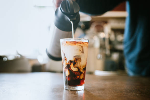 barista giet melk in koude brouwsel koffie - coffee stockfoto's en -beelden