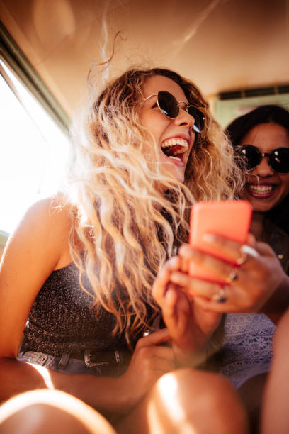 bas de bikini fille regardant téléphone intelligent avec route voyage ami - travel photos et images de collection