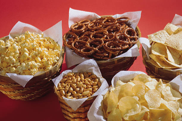 baskets of assorted snacks - junk food stockfoto's en -beelden