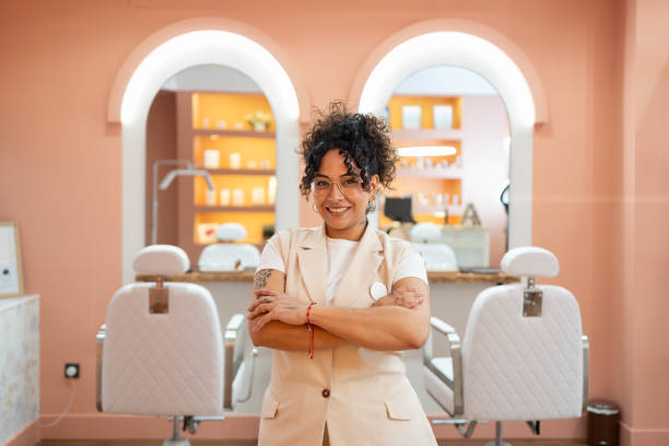 beautician exuding confidence and professionalism, smiling in a stylish beauty salon while offering top notch services with joy - hairstyle stock pictures, royalty-free photos & images