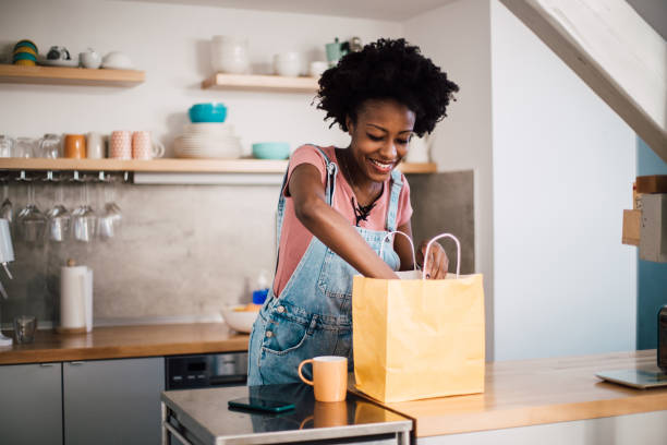 beautiful african-american woman preparing to eat her ordered food - junk food stock pictures, royalty-free photos & images