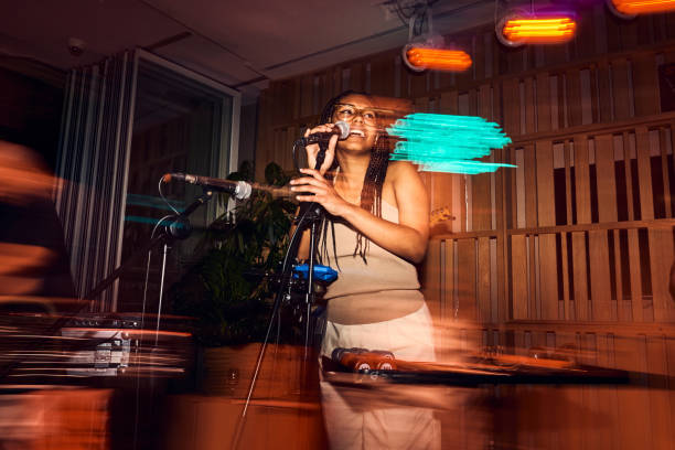 beautiful black girl talking into microphone during live jazz show - concert stock pictures, royalty-free photos & images
