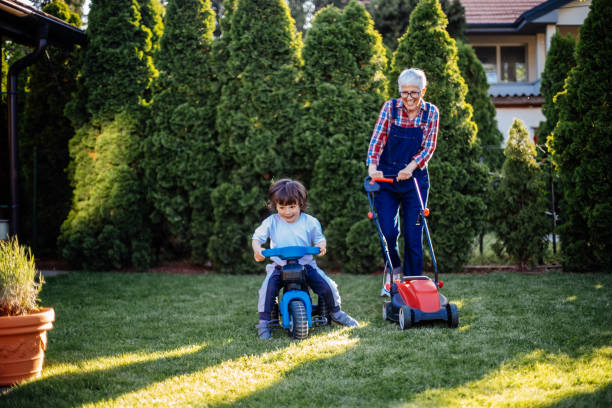 beautiful boy having fun with grandmother in the garden - garden decoration stock pictures, royalty-free photos & images