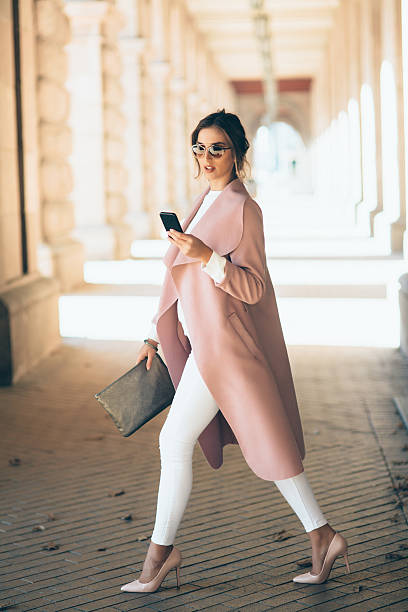 beautiful elegant woman texting outdoors - fashion stock pictures, royalty-free photos & images