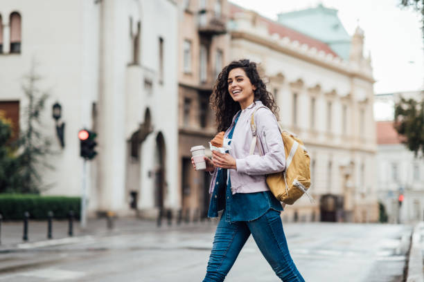 beautiful woman having her breakfast in the city - junk food stock pictures, royalty-free photos & images