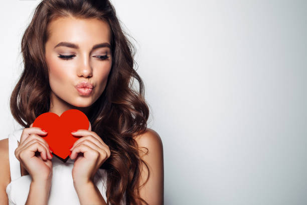 beautiful woman holding artificial heart - hairstyle stock pictures, royalty-free photos & images