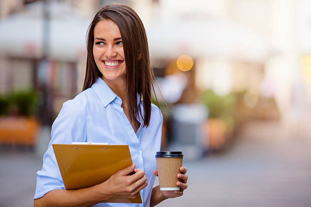 beautiful young business woman smiling and holding documents and - junk food stock pictures, royalty-free photos & images