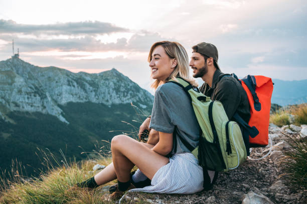 beautiful young couple relaxing after hiking and taking a break - travel stock pictures, royalty-free photos & images