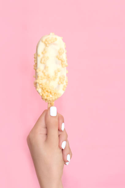 beauty white manicure. woman hand with nails art holding ice cream on pink background. close up of female hands with fashion french nails. art nail design. high quality image. - nails art stock pictures, royalty-free photos &