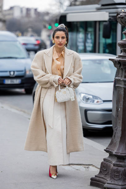 Bettina Looney wears beige fleece coat, high waisted skirt, brown blouse, Miu Miu bag, pointed heels outside Zimmermann during Paris Fashion Week -...