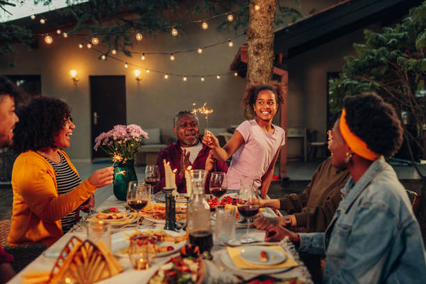 big family garden party celebration, gathered together at the dining table outdoors - garden decoration stock pictures, royalty-free photos & images