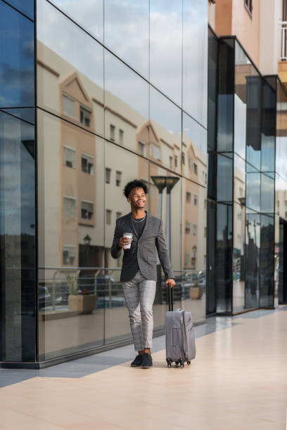 black entrepreneur with suitcase walking along street - junk food stock pictures, royalty-free photos & images
