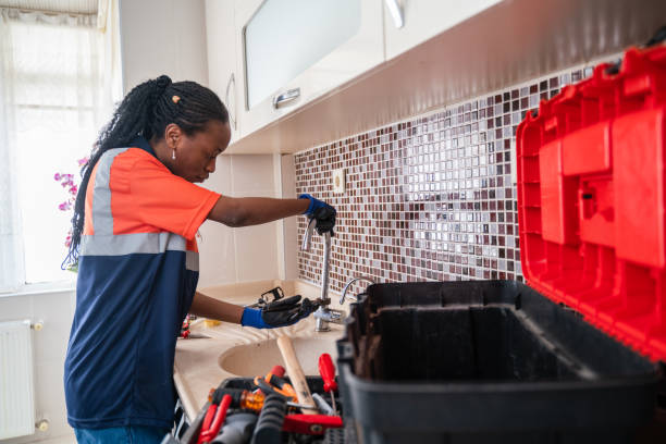 black female plumber fixing a leak in the kitchen sink of a house - home decoration stock pictures, royalty-free photos & images