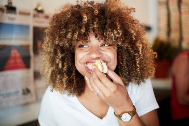 black woman biting sandwich - food stock pictures, royalty-free photos & images