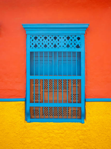 blue window in a orange and yellow background, characteristic of the town of jerico, antioquia, colombia - garden decoration stock pictures, royalty-free photos & images