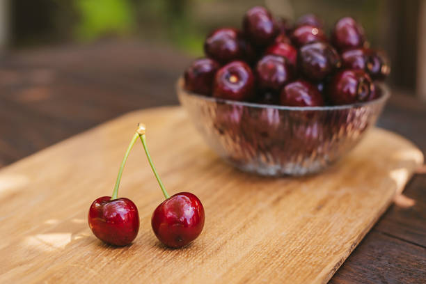 bowl of cherries on wood background - home decoration stock-fotos und bilder