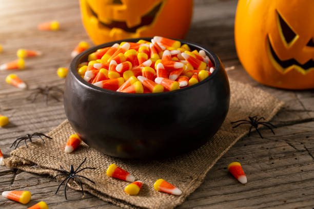 bowl of halloween candy corns and jack o' lantern - home decoration stock pictures, royalty-free photos & images