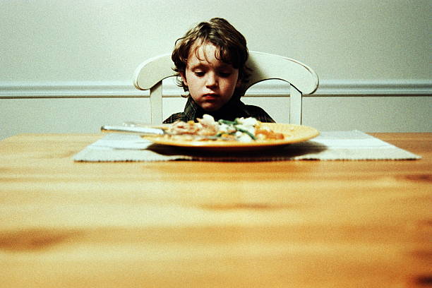 boy alone at dinner table, not eating - food stock pictures, royalty-free photos & images