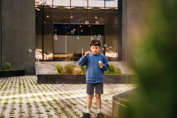 boy blowing bubbles - garden decoration stock pictures, royalty-free photos & images