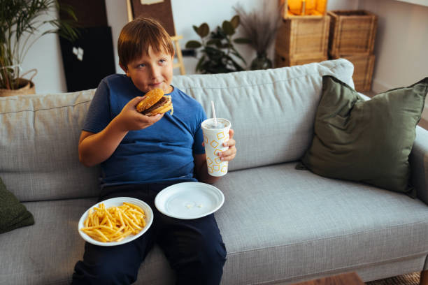 boy eating junk food at home - junk food stock pictures, royalty-free photos & images