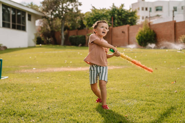 boys hiting a piñata at a party - garden decoration stock pictures, royalty-free photos & images