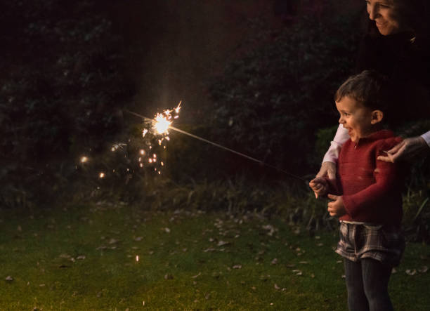 boys holding spraklers for new year's eve - garden decoration stock pictures, royalty-free photos & images