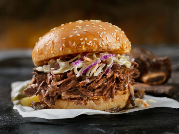 braised beef short rib sandwich with coleslaw on a brioche bun - junk food stock pictures, royalty-free photos & images