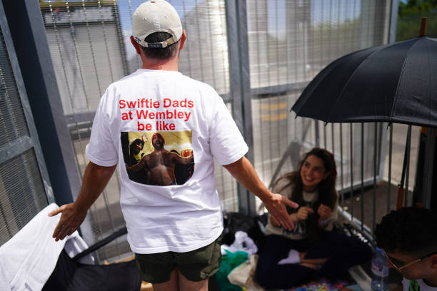 Brian Wood, a Taylor Swift fan from the United States, shows the back of his t-shirt as he waits at the Red Zone the VIP entrance to Wembley Stadium...